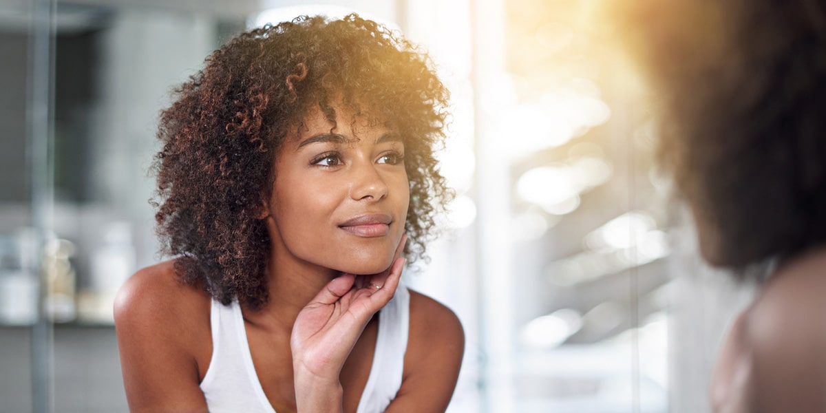 woman admiring her smooth skin in the mirror